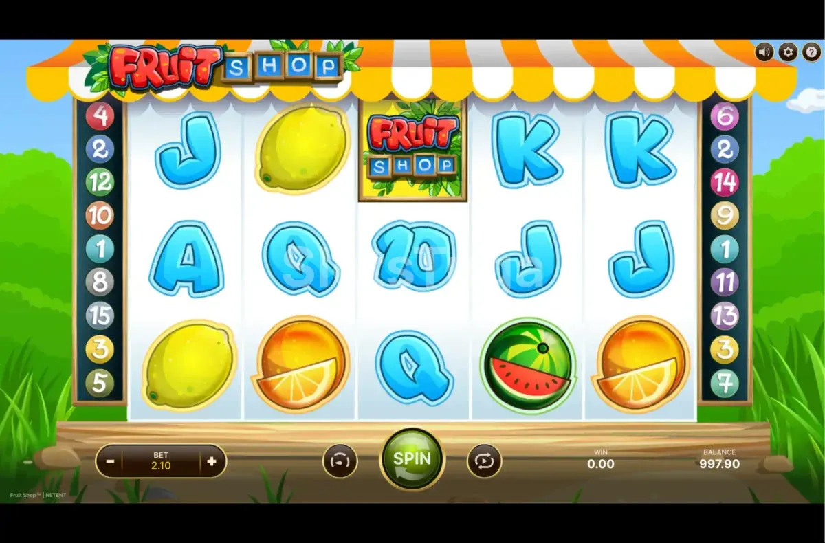 O Fruit Shop original: cinco rolos sob um toldo às riscas com limões, laranjas, uma melancia e letras de cartas azuis, o wild Fruit Shop no terceiro rolo e os números das quinze linhas nas laterais.