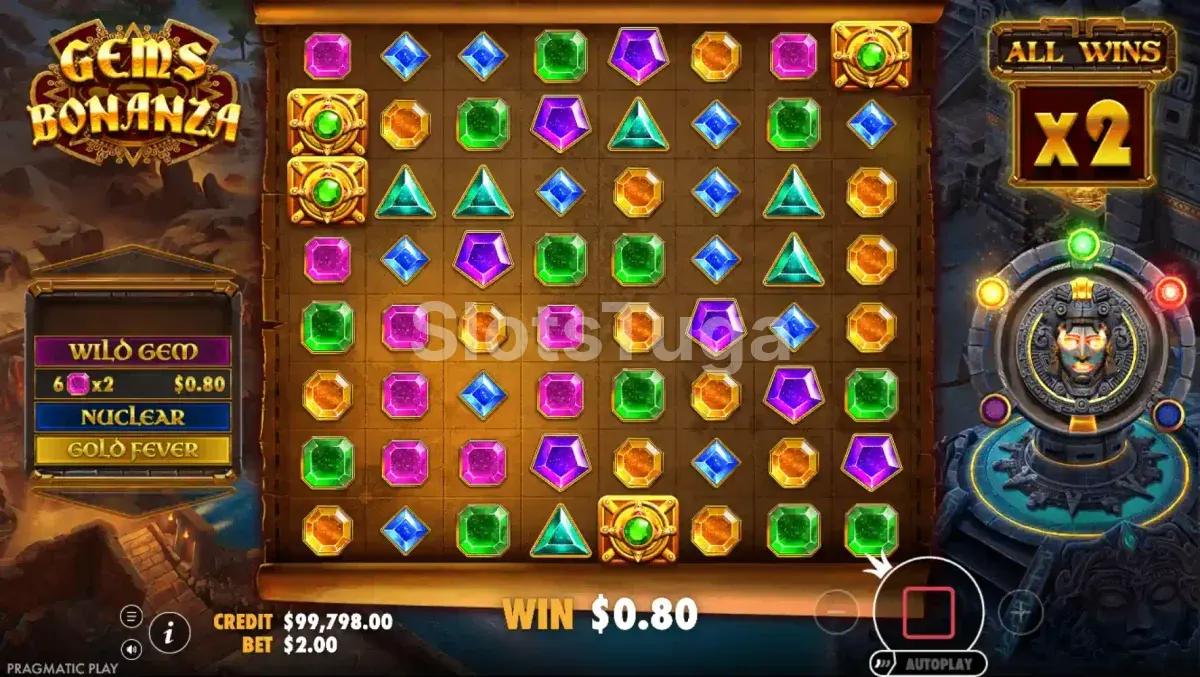 Gems Bonanza: grelha de oito por oito cheia de gemas cor-de-rosa, azuis, verdes, roxas, laranja e esmeraldas triangulares, com três molduras douradas a marcar posições, o painel Wild Gem, Nuclear e Gold Fever à esquerda e um multiplicador All Wins x2 à direita, num templo asteca.