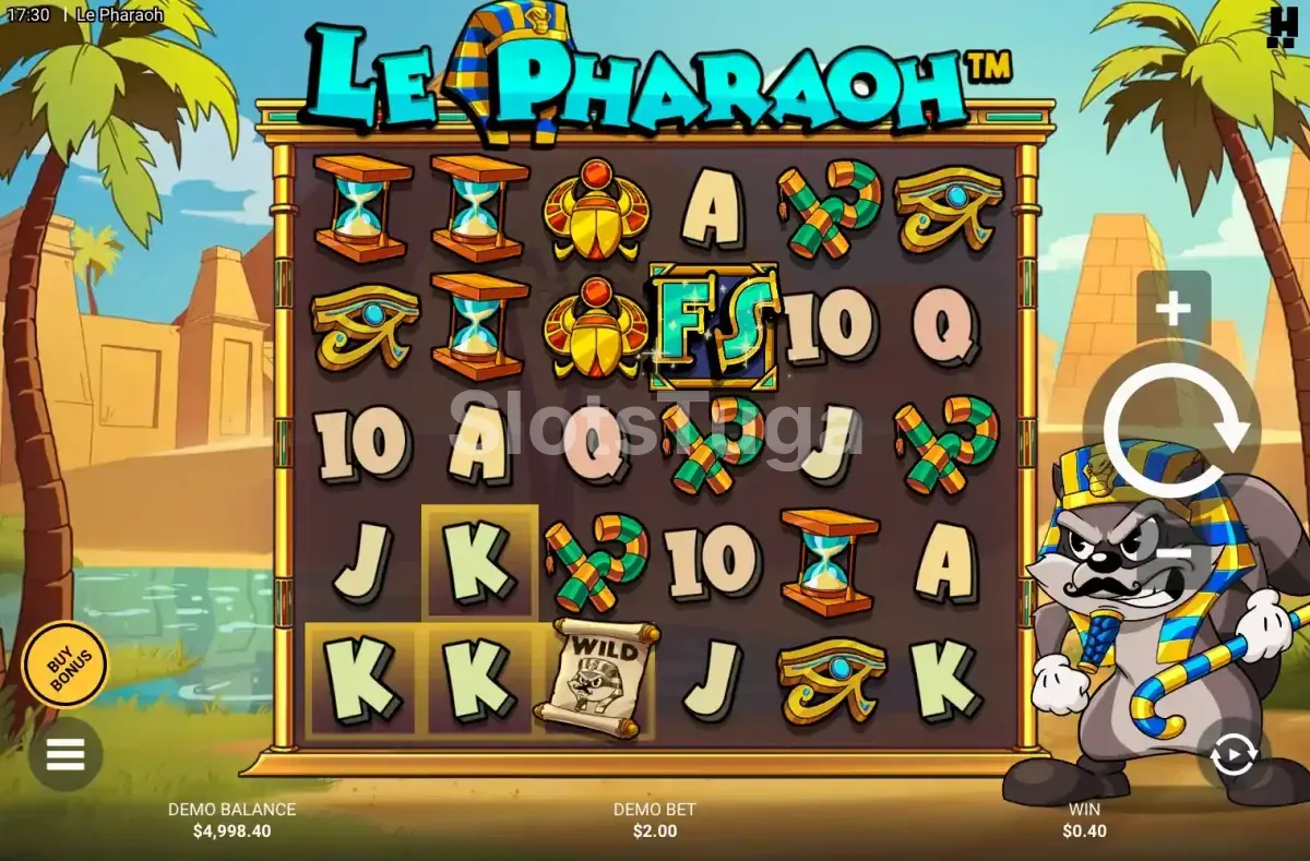 Le Pharaoh: o guaxinim da série Le vestido de faraó ao lado de uma grelha com escaravelhos, olhos de Hórus e ampulhetas, quadrados dourados em baixo e pirâmides e palmeiras ao fundo.