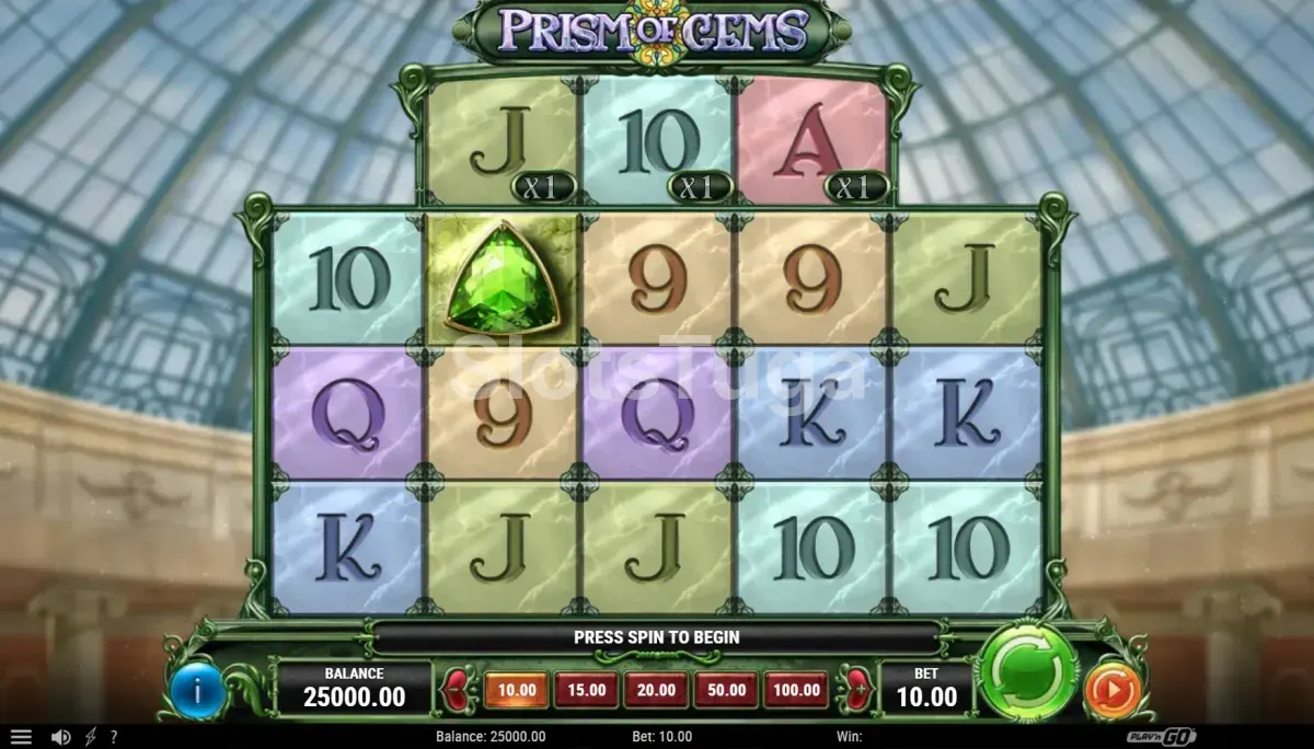 Prism of Gems em jogo base: grelha em forma de losango de três, quatro, quatro, quatro e três posições, com letras de cartas em azulejos coloridos e uma esmeralda verde, três multiplicadores x1 no topo, sob a cúpula de vidro e ferro de um museu.